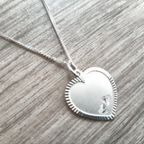 Close-up Graveerhanger Echt Zilver in de vorm van een hart, bewerkte rand en twee kleine hartjes als detail voorzijde